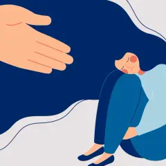 Wyciągnięta dłoń oferuje wsparcie. Kobieta skulona, potrzebująca pierwszej pomocy psychologicznej, znajduje pocieszenie.