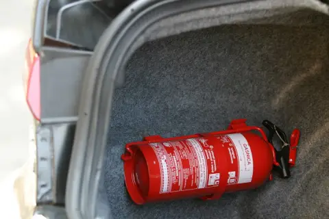 Czerwona gaśnica w bagażniku. Brak gaśnicy to ryzyko mandatu.