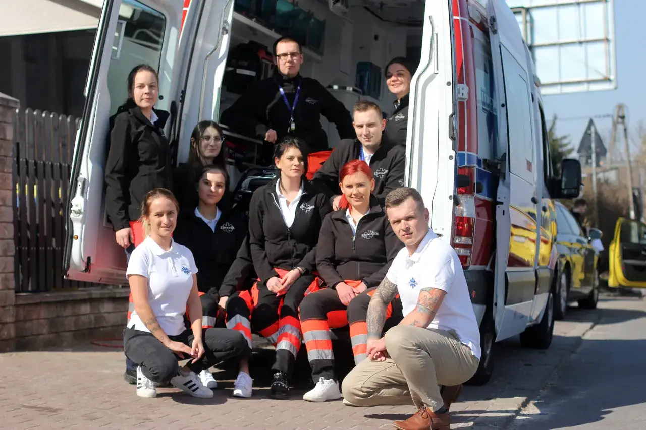 Zespół ratowników KPP w pracy, gotowy do akcji przy ambulansie.